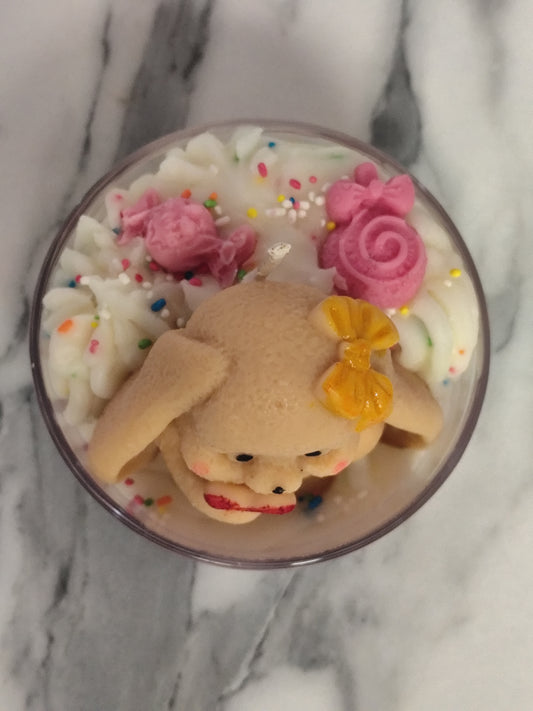Candle with a bear decoration on a marble surface
