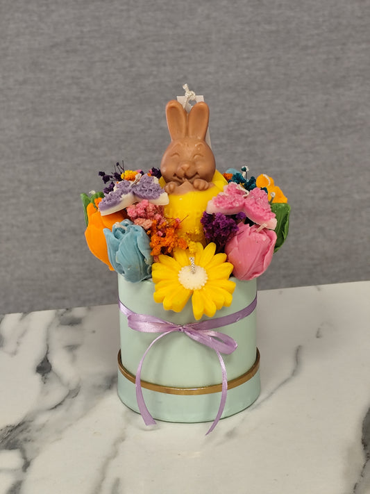 colorful candle flowers and a bunny figure on a marble surface.