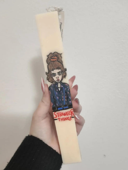 Candle with a 'Stranger Things' design on a plain background