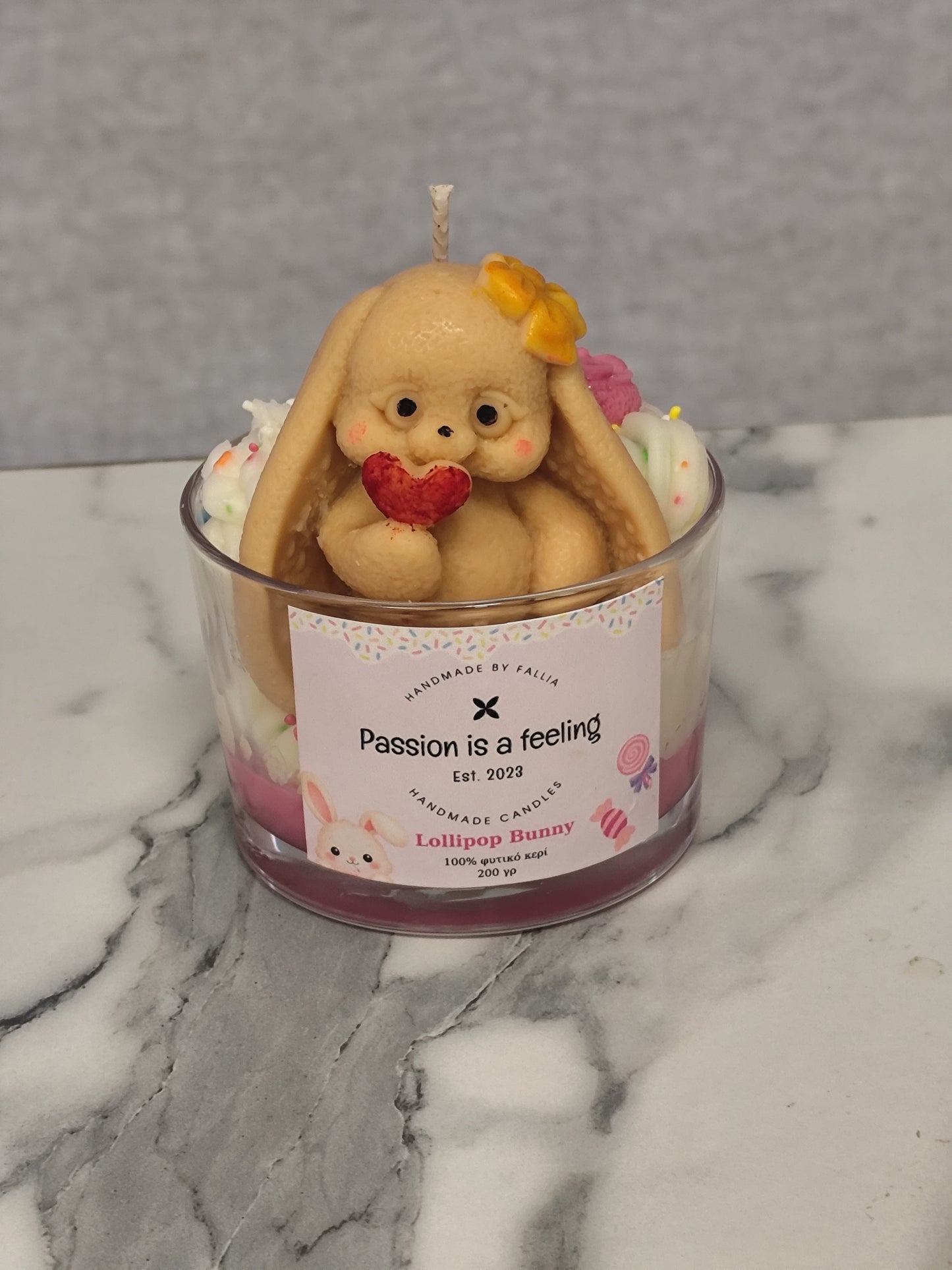 Candle with a bunny figurine and heart on a marble surface