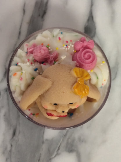 Candle with a bear decoration on a marble surface