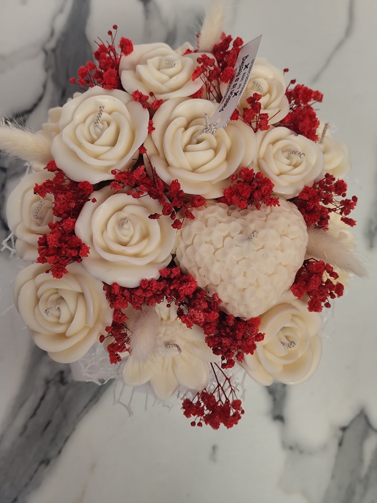 Bouquet of white roses with red flowers on a marble surface